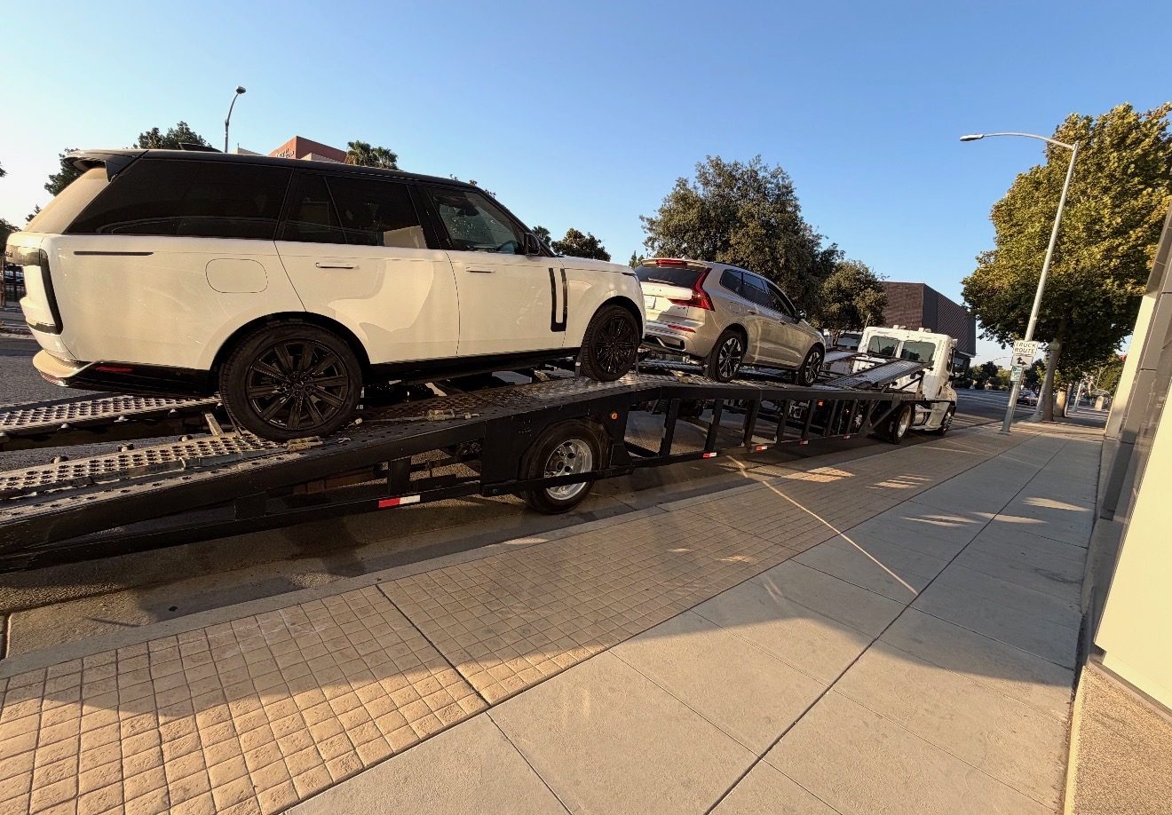 Big Boss car carrier loaded with a white Range Rover and SUV